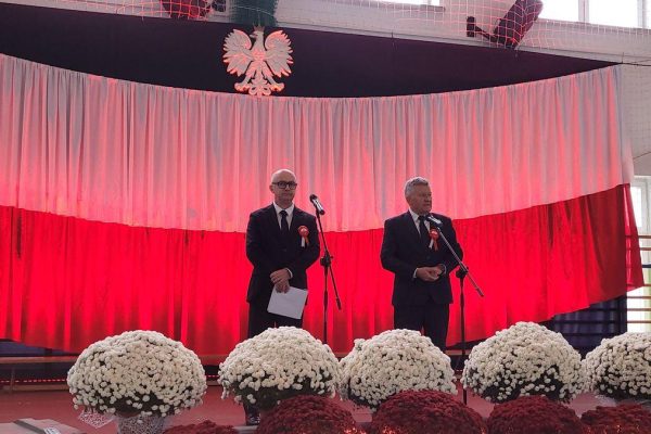Dwie osoby przy mikrofonach na biało-czerwonej scenie Festiwalu Pieśni Patriotycznych.