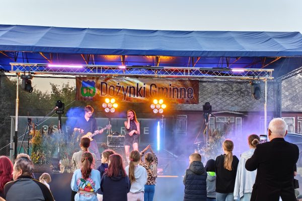 Muzycy podczas koncertu na oświetlonej scenie dożynek.