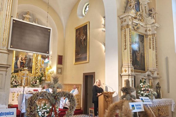 Wieńce dożynkowe i kosze z plonami przy ołtarzu.