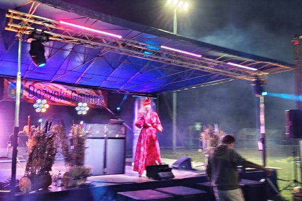 Muzycy podczas koncertu na oświetlonej scenie dożynek.