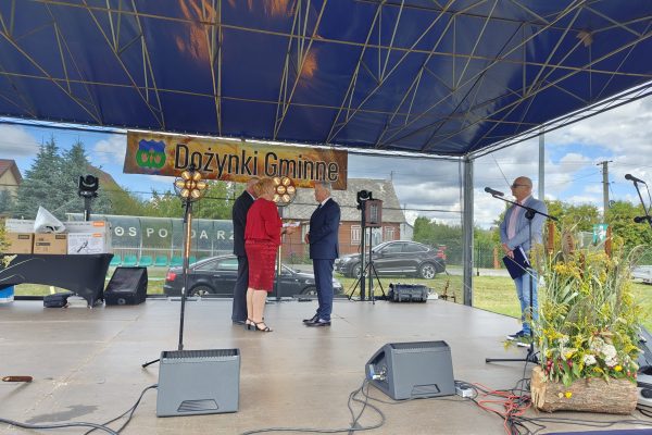 Wystąpienie przy mikrofonie na plenerowej scenie dożynek.